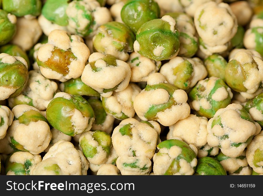 A macro shot of a heap of wasabi peas.