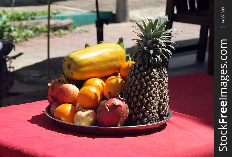 Tropical fruits on table, pineapple, oranges, apple etc