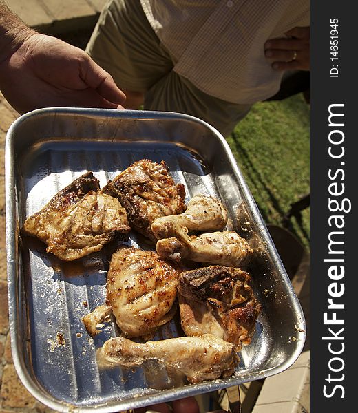 Grilling chicken drumsticks and pieces in a  bbq tray. Grilling chicken drumsticks and pieces in a  bbq tray