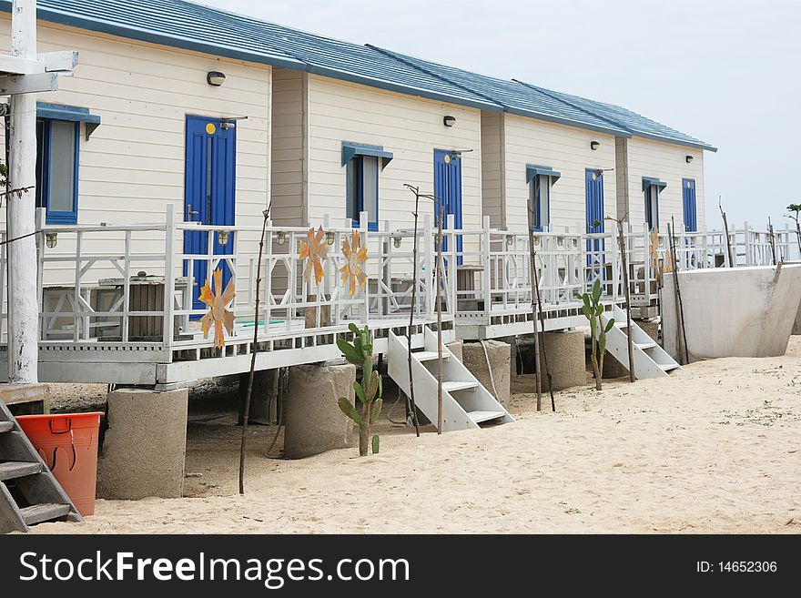 These are simple beach huts, big enough for a family.  They have a balcony and there are some cactus in front of them.