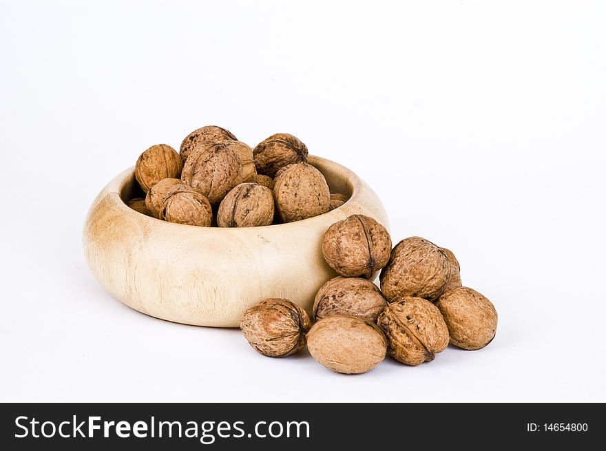 Walnuts in wooden bowl on white background