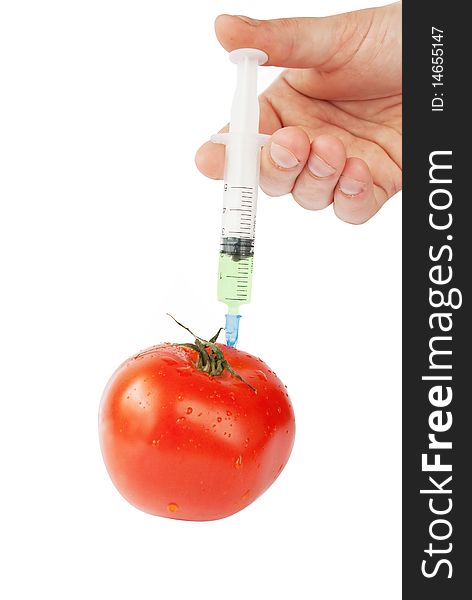 Human hand with syringe and red tomato