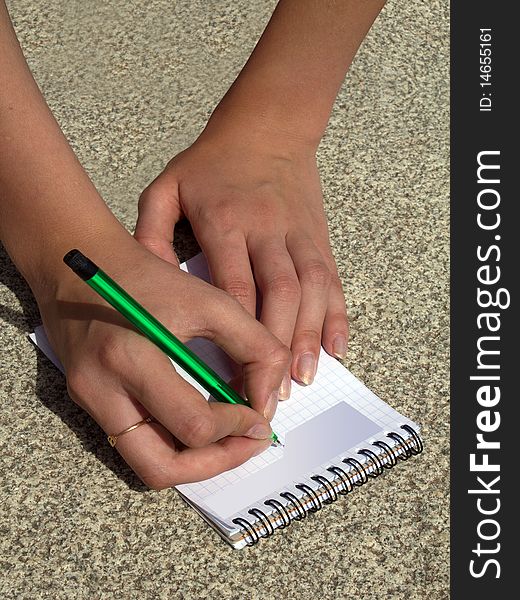 Hands female with a pencil and a notebook. Hands female with a pencil and a notebook