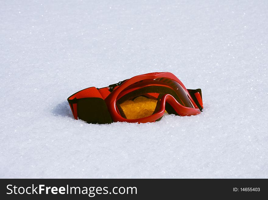 Sun-blinkers for rolling on the skis of red color lie on white to snow. Sun-blinkers for rolling on the skis of red color lie on white to snow