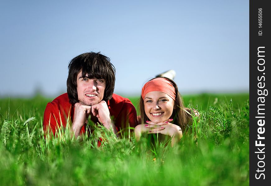 Girl in kerchief and smiling boy on grass. Girl in kerchief and smiling boy on grass