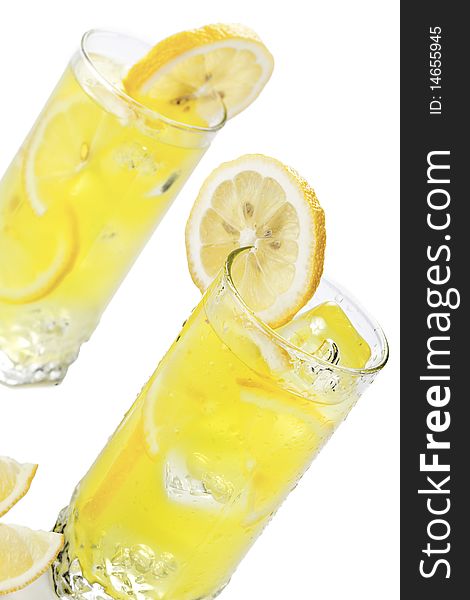 Glass of freshly made cold lemon beverage with pieces of the fruit. Glass of freshly made cold lemon beverage with pieces of the fruit