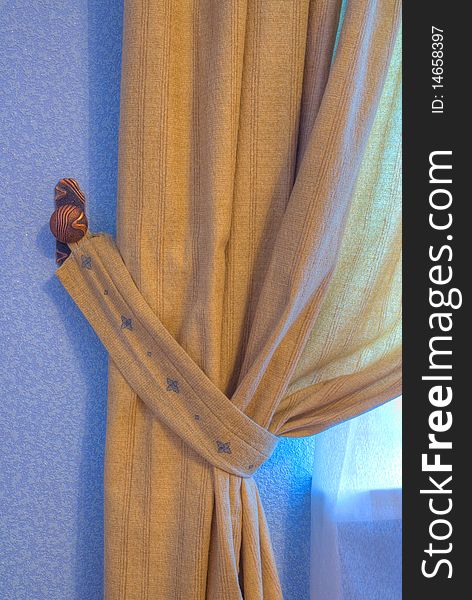Brown curtain in the wings with a blue wall
