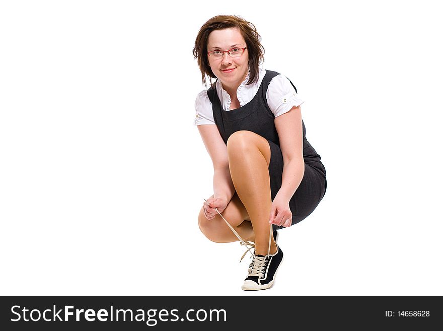 Female, office worker ties her sporty shoes, studio shoot isolated on white background. Female, office worker ties her sporty shoes, studio shoot isolated on white background