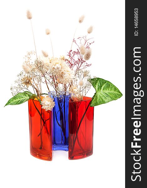 Bouquet from dry herb and green sheet in colour glass vase on white background