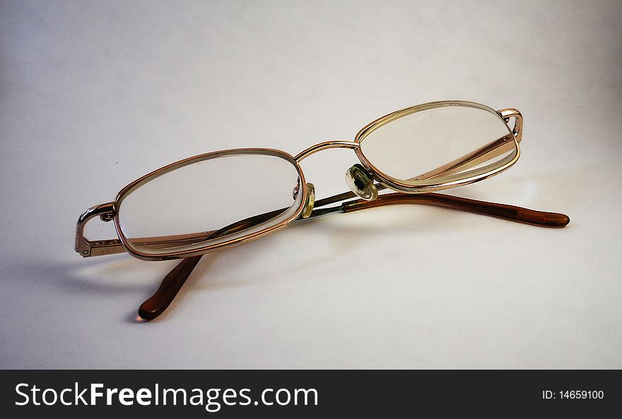A pair of reading glasses with thin frame and plastic lenses.