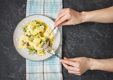 Female Hand Hold Fork And Knife. Eggs Benedict With Salad And Avocado On Stone Background Royalty Free Stock Image Female Hand Hold Fork And Knife. Eggs Benedict With Salad And Avocado On Stone Background Royalty Free Stock Image