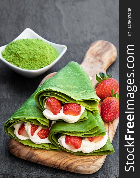 Matcha Green Tea Crepe With Whipped Cream And Strawberry On Serving Board