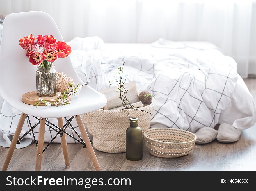 Objects of home cozy decor in the interior of the room .With beautiful red tulips .The concept of decor and home atmosphere. Objects of home cozy decor in the interior of the room .With beautiful red tulips .The concept of decor and home atmosphere