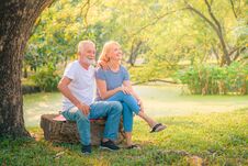Elderly Couple Reading Newspaper In Garden At Sunset. Concept Couple Elder Love Royalty Free Stock Photography