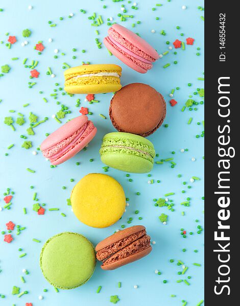 Macarons. french multicolored macaroons cakes. small french sweet cake on bright blue background. Dessert. Sweets. top view