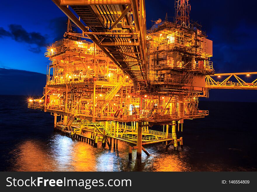 The large offshore oil rig at night with twilight background. The large offshore oil rig at night with twilight background