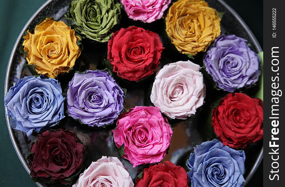 Dried colored roses lying on a tray. Nostalgia, vintage and fragrance concept
