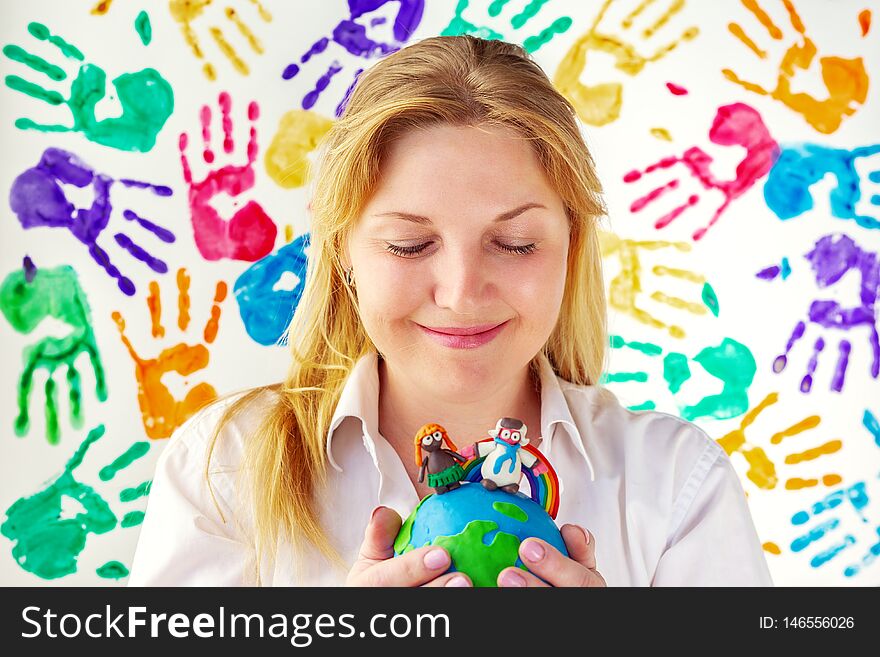 Attractive woman holds in her hands the planet Earth of plasticine