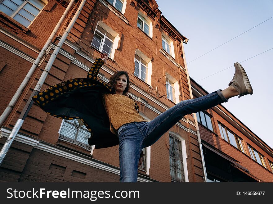 Young woman raises her leg up outdoor in evening