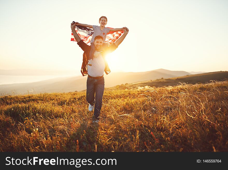 Happy Family Father And Child  With Flag Of United States Enjoying  Sunset On Nature