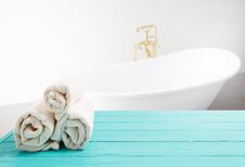 Free Blue Wooden Shelf With Rolled Towels On Bathroom Background. Wood Desk Table With Top View And Copy Space Near White Bath At Hotel Stock Photos - 146583783