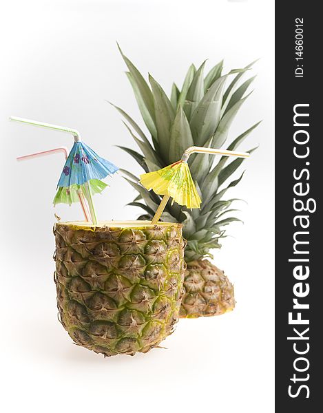 Pineapple with three straws and umbrellas isolated