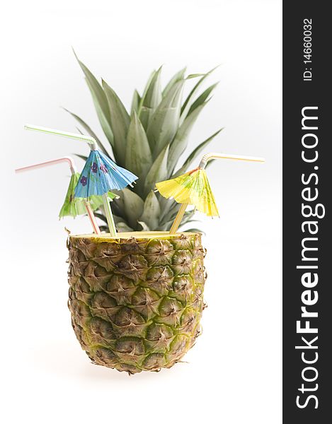 Pineapple with three straws and umbrellas isolated