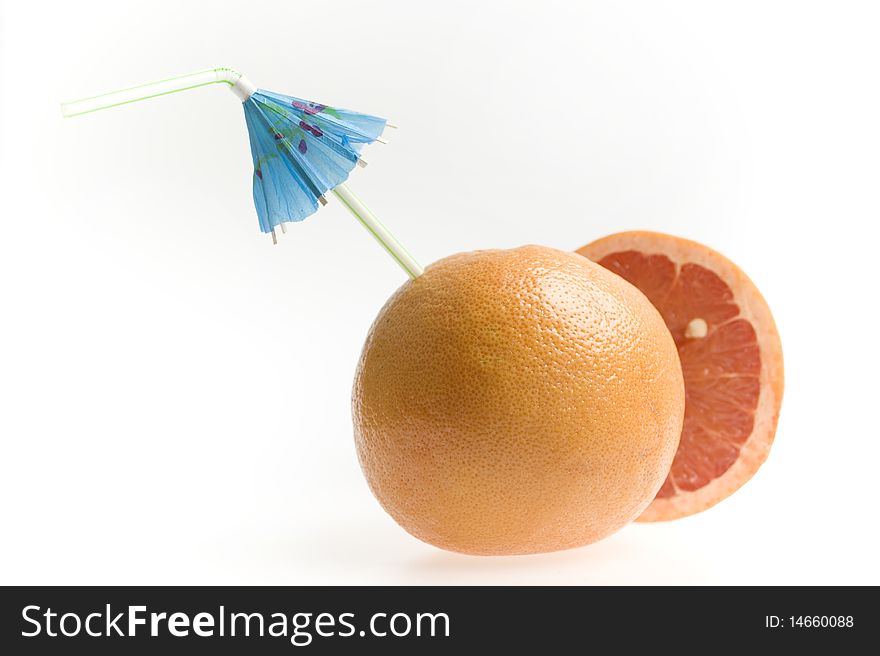 Grapefruit with straw and umbrella isolated on white background