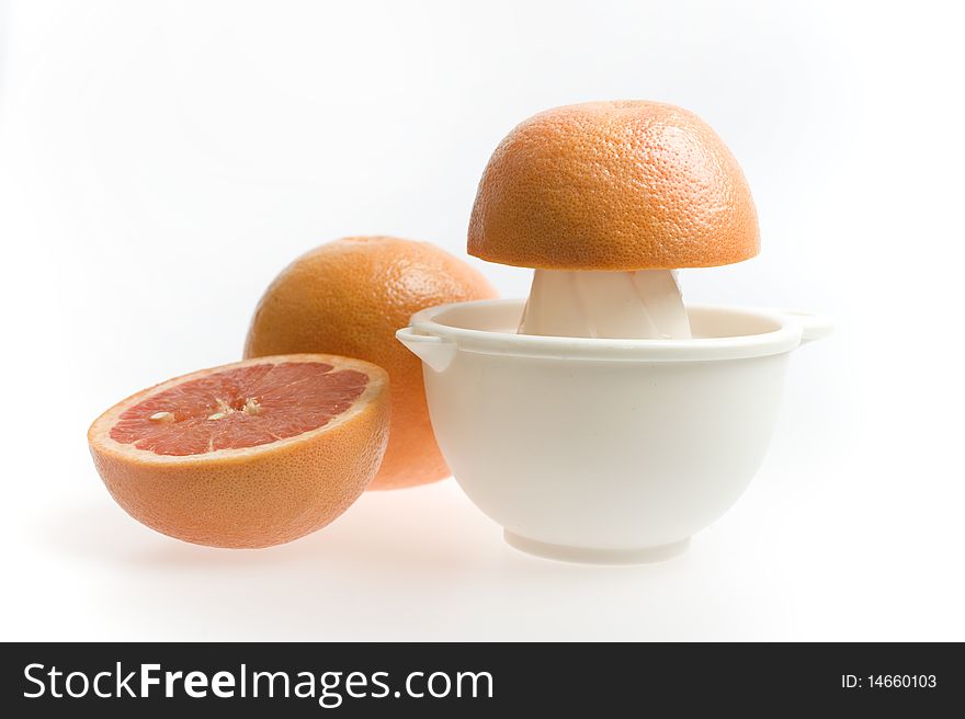 Red grapefruit being squeezed by hand isolated on white background