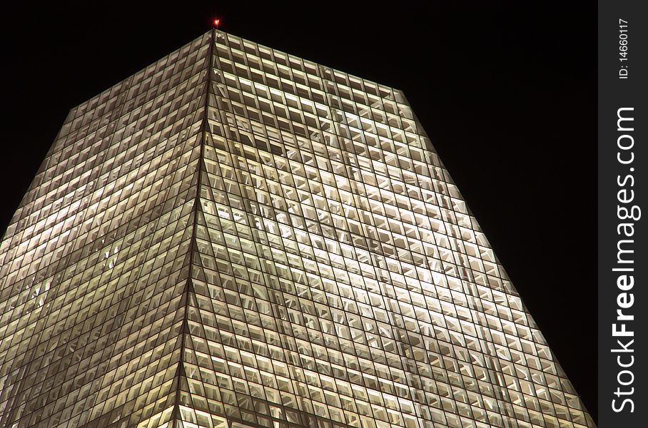 The illuminated trapezoidal roof structure of an office building constructed of thousands of square frames. The illuminated trapezoidal roof structure of an office building constructed of thousands of square frames