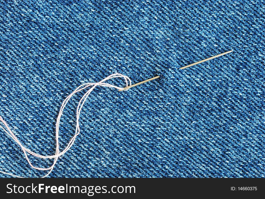 The needle with a thread through the jean