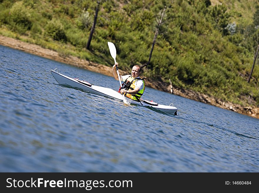 Man enjoying a morning in a dam kayaking. Man enjoying a morning in a dam kayaking