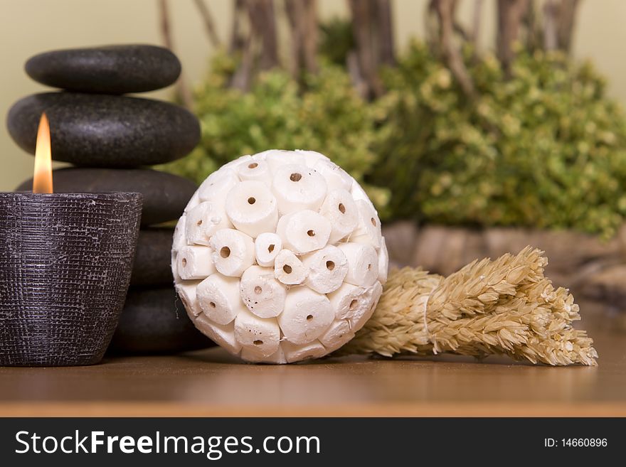 Candle, massage stones in front of a bonsai tree. Candle, massage stones in front of a bonsai tree