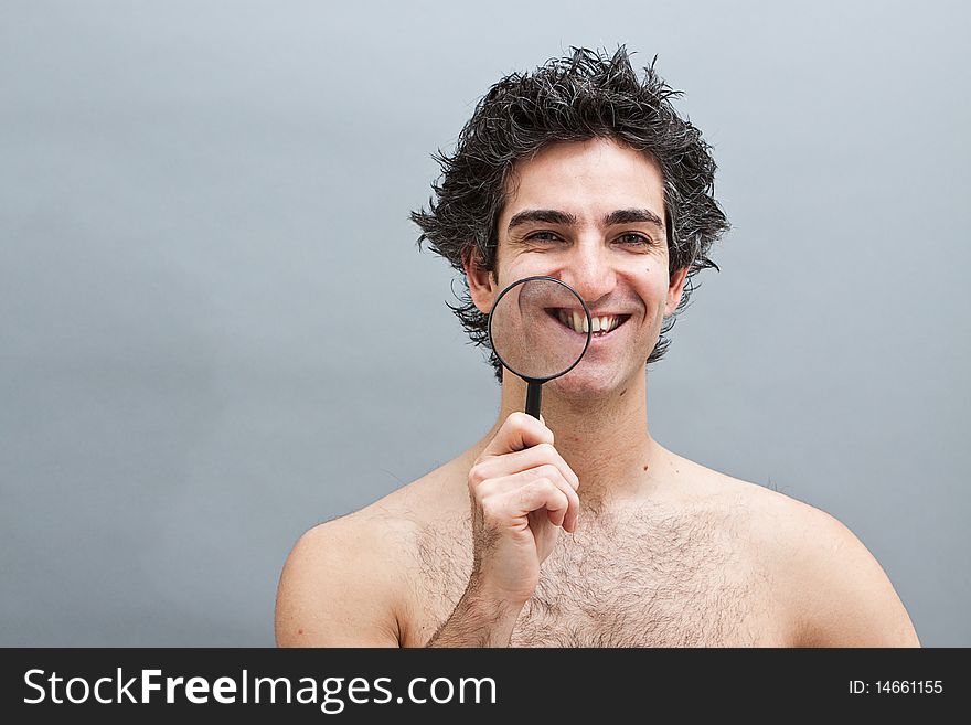 Man examining his teeth with magnifier. Man examining his teeth with magnifier
