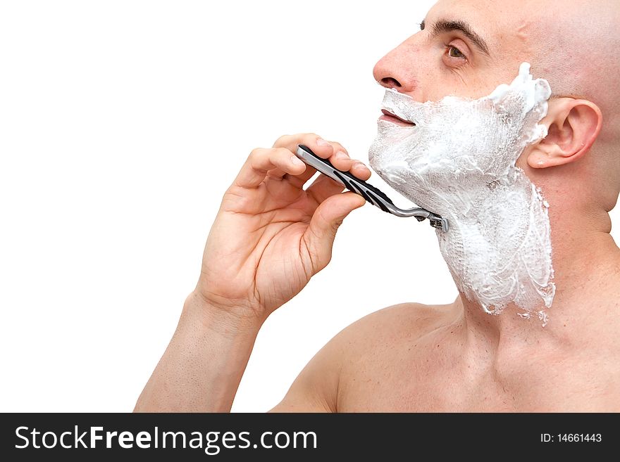 Young man shaving with a razorblade