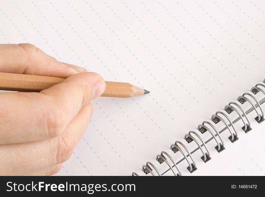 Pencil in hand, wrote in a notebook on a white background