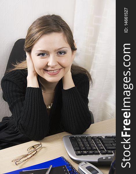 Secretary or Businesswoman a black dress sits at a desktop. Secretary or Businesswoman a black dress sits at a desktop.