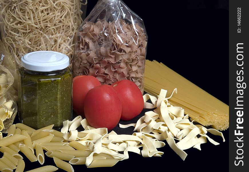 The picture shows tomato, pesto and some noodles