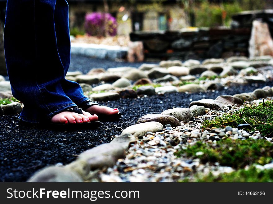 Feet on a stone path in a garden serene
