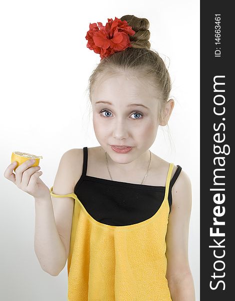 A little cute girl eating an lemon
