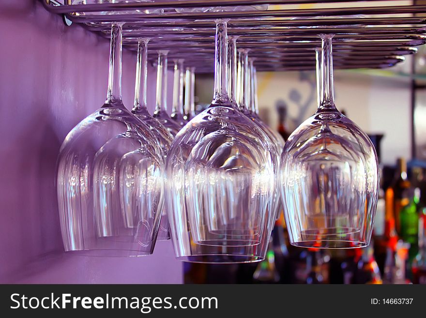 Photo of wine glasses in bar and purple wall