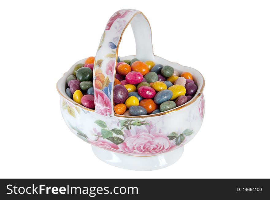 Multi-colored candies in a porcelain vase isolation