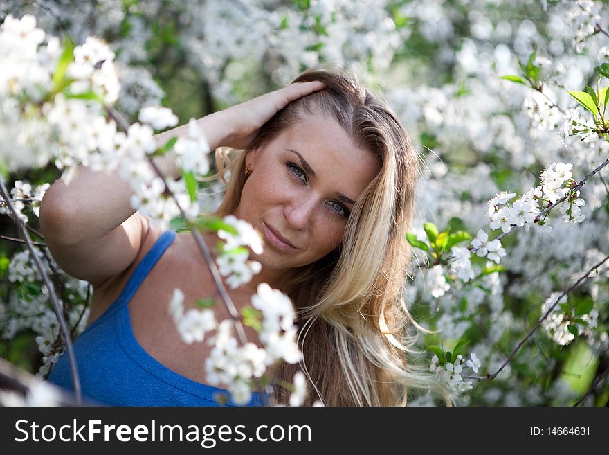 Blonde model in the cherry garden on spring. Blonde model in the cherry garden on spring