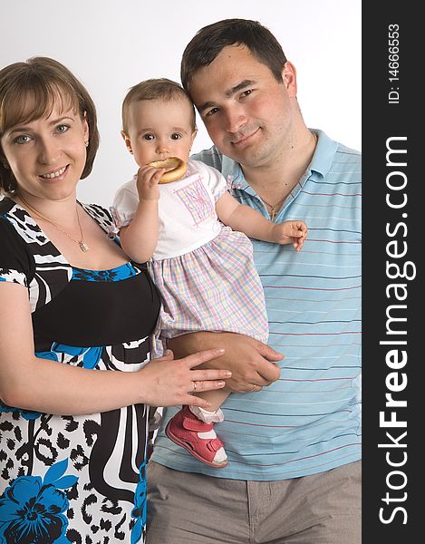 Happy family portrait of a baby with her parents over a white background