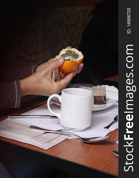 Woman holding a passion fruit for breakfast with cup of tea. Woman holding a passion fruit for breakfast with cup of tea