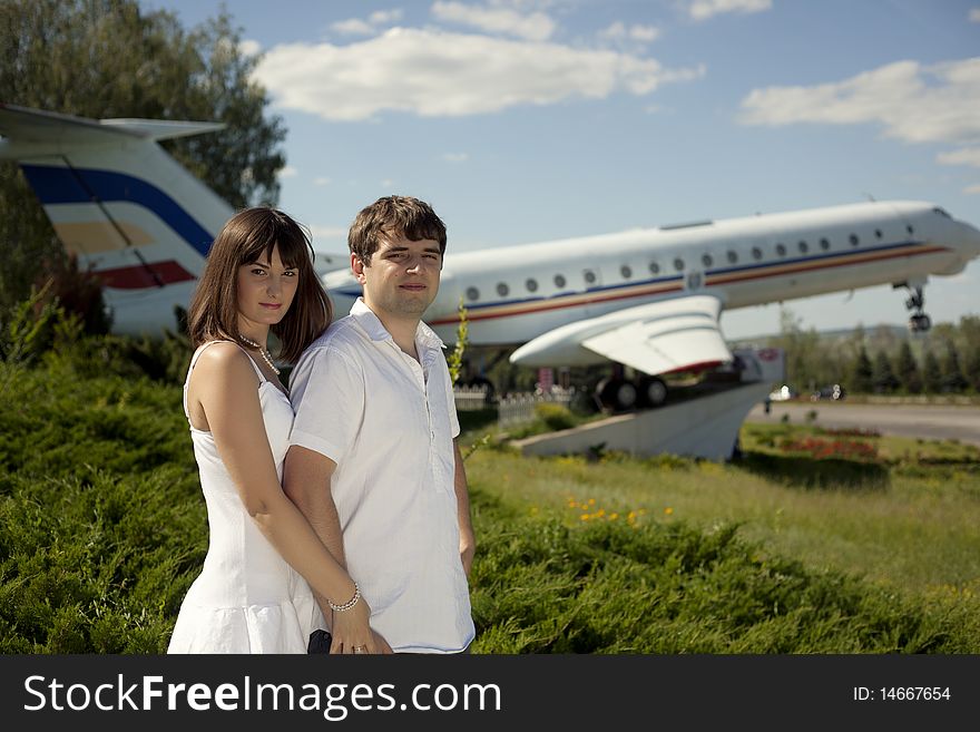 Couple posing with an airplane behind. Couple posing with an airplane behind