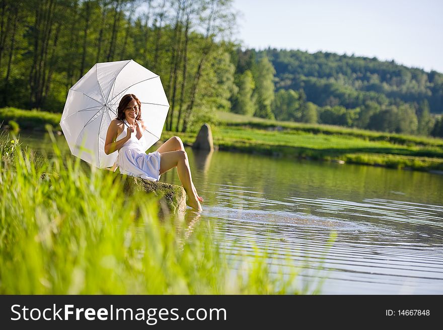 Spring - Happy romantic woman sitting by lake