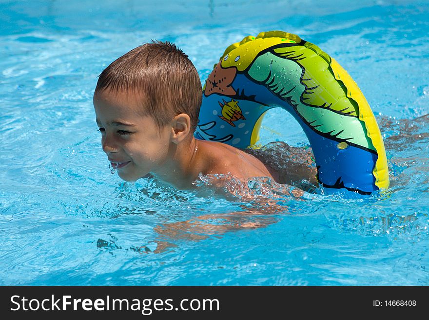 Little boy swimming in swimming pool with life belt. Little boy swimming in swimming pool with life belt