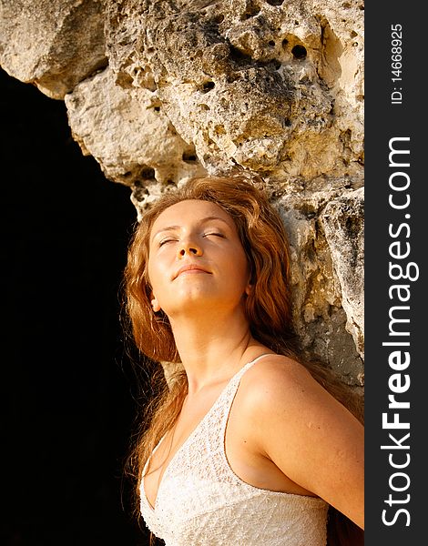 Portrait of the girl standing at a stone wall