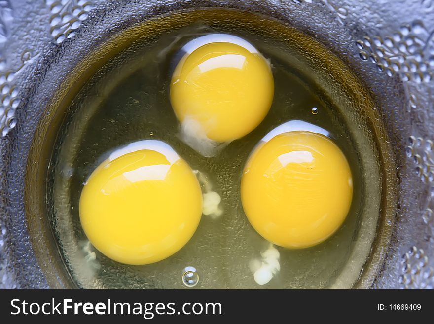 Three egg yolk on glass bowl. Three egg yolk on glass bowl